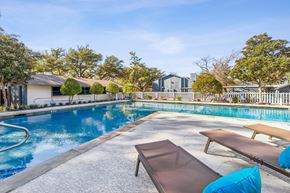 Dallas apartment for rent - A pool with a bench and a table in front of it.