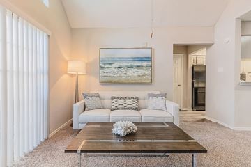 Bedford apartment for rent - A living room with a white couch and a painting of a beach scene on the wall.