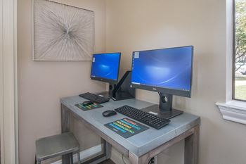 A computer desk with two monitors and a keyboard and mouse on it