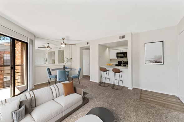 North Richland Hills apartment for rent - a living room with a couch a table and chairs and a kitchen in the background at The Hudson, North Richland Hills, TX