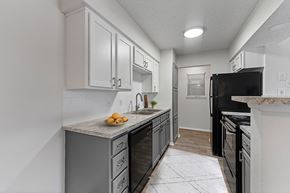 North Richland Hills apartment for rent - a kitchen with white cabinets and black appliances at The Hills at Ironhorse, North Richland Hills, Texas