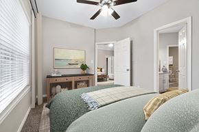 Denton apartment for rent - a bedroom with a large bed and a ceiling fan at Fountains of Denton in Denton, TX