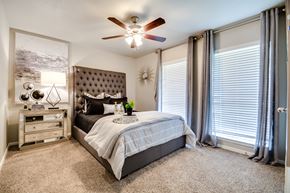 Dallas apartment for rent - a bedroom with a bed and a ceiling fan