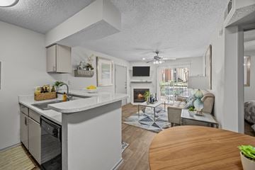 Lewisville apartment for rent - A modern kitchen with a dining table and a living room area.