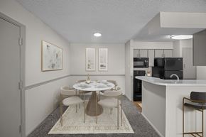 Lewisville apartment for rent - A modern dining room with a white table and chairs.