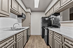 Round Rock apartment for rent - A kitchen with a black refrigerator and a white countertop.at Rock 35, Round Rock, TX, 78681