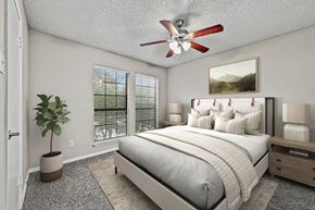 Plano apartment for rent - a bedroom with a bed and a ceiling fan at Legacy Apartments in Plano, TX