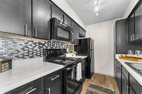 Dallas apartment for rent - a kitchen with black cabinets and white countertops at Vesper, Dallas, 75254