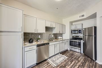 Lewisville apartment for rent - A kitchen with white cabinets and stainless steel appliances.