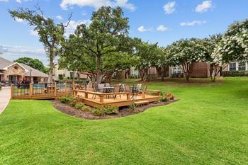 A large yard with a wooden deck and a pool