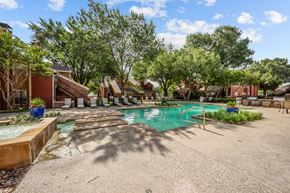 Arlington apartment for rent - A pool surrounded by trees and a building in the background.