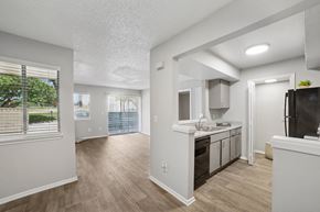 Irving apartment for rent - A kitchen with white cabinets and a black fridge.