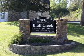 Carver apartment for rent - A sign for Bluff Creek Apartments is displayed in front of a building.