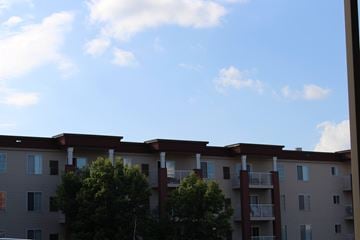 Waconia apartment for rent - Apartment building with balconies and trees in front.