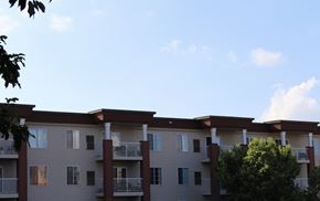 Waconia apartment for rent - Apartment building with balconies and trees in front.