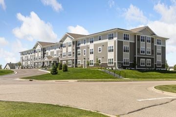 Carver apartment for rent - A large, multi-story apartment building with a parking lot in front.