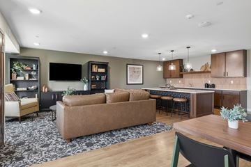 Carver apartment for rent - A modern living room with a brown sofa and a wooden dining table.