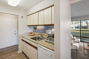 Flushing apartment for rent - a kitchen with white cabinets and a sink and a window