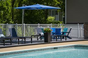 Southfield apartment for rent - a swimming pool with blue chairs and a blue umbrella