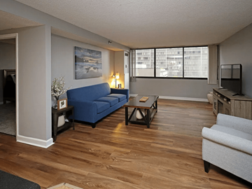Cleveland apartment for rent - A living room with a blue couch and wooden floors.