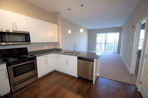 Fort Wayne apartment for rent - A kitchen with white cabinets and a black stove top oven.