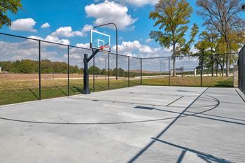 Outdoor basketball court with hoop and fencing