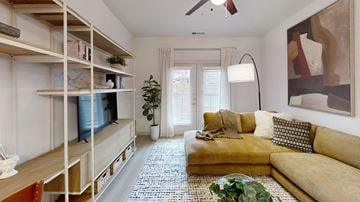 Austin apartment for rent - A living room with a yellow couch and a television on a stand.