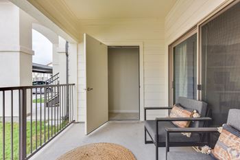 A balcony with a chair and a table.