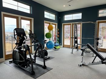 A gym with a variety of equipment including treadmills, stationary bikes, and weight machines.