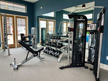 A gym with a variety of equipment including a leg press machine.