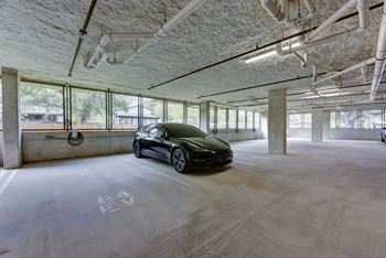 Covered parking garage with concrete columns and natural light