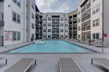 Resort style pool with surrounding lounge chairs
