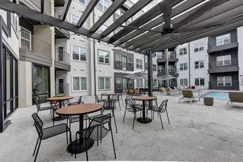 Outdoor courtyard with dining tables and pool area