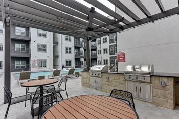Covered outdoor grilling area with stone counters