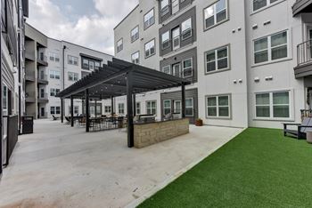 Covered patio with outdoor dining and artificial turf