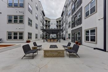 Courtyard fire pit with surrounding modern chairs