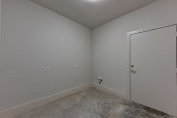 Empty utility room with concrete floor and hookups