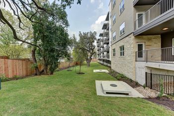 Backyard lawn area with concrete pads and balconies