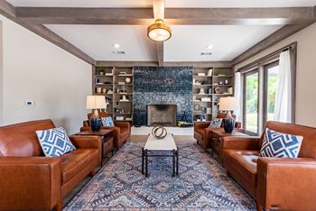 A living room with leather couches and a fireplace