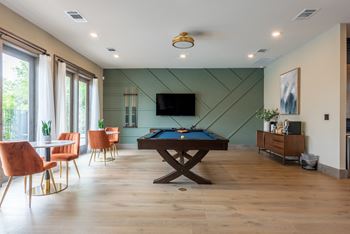 A game room with a pool table and a flat screen tv