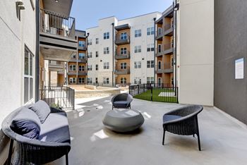A patio with a chair, a couch and a table.