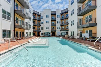 A swimming pool in front of apartment buildings.