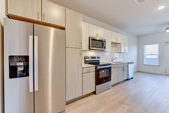 A modern kitchen with a stainless steel refrigerator and wooden cabinets.