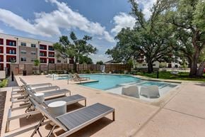 Austin apartment for rent - A pool with sun loungers and a building in the background.