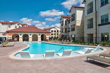 Resort style pool with sundeck and lounge chairs