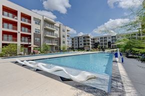 Manor apartment for rent - A large swimming pool in front of apartment buildings.