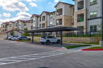 Covered parking with apartment buildings and stone retaining wall
