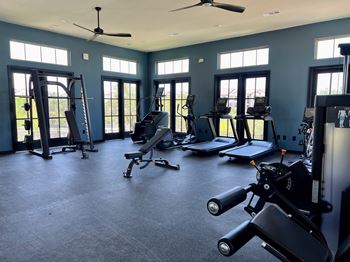 A gym with exercise equipment and windows