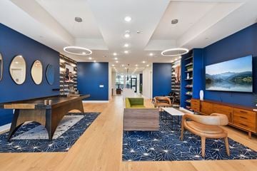 Austin apartment for rent - a living room with blue walls and a tv and a table and chairs