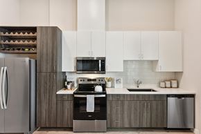 Austin apartment for rent - Kitchen with wood grain cabinets and white uppers at Bridge at Windsor Park Apartments, Texas, 78723